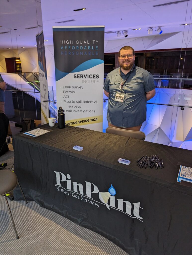 Lee Clyne standing at the PinPoint Natural Gas Services booth at the 2024 AAMP 10K Lakes conference